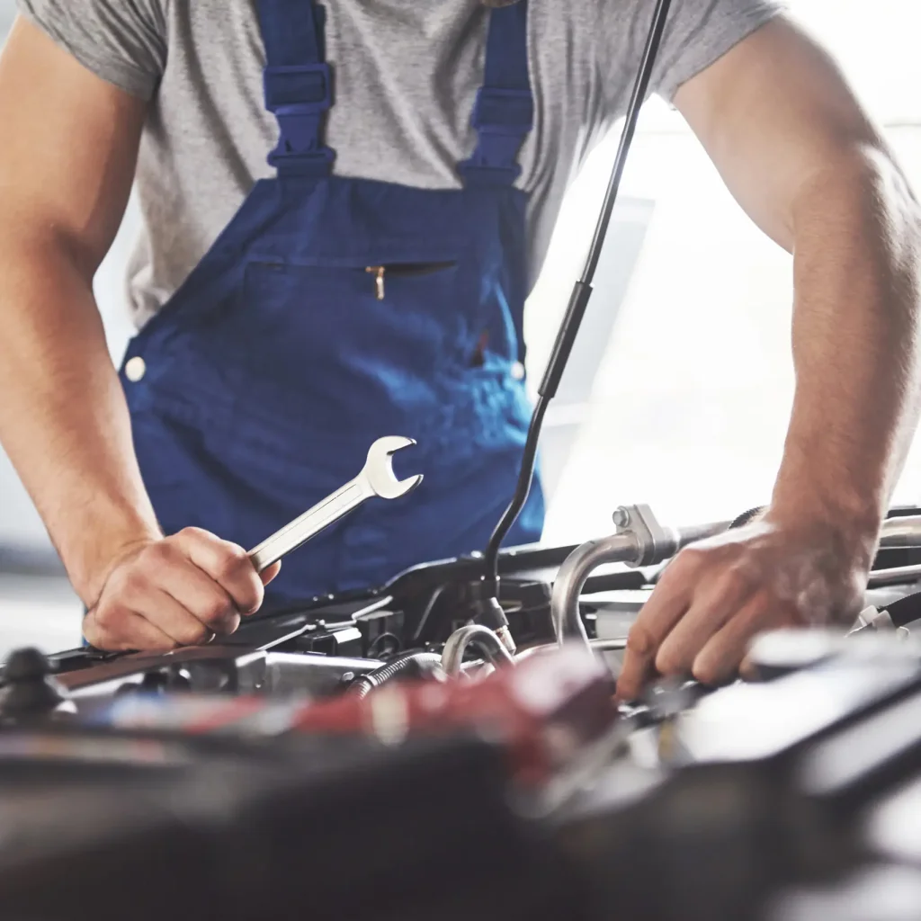 muscular car service worker repairing vehicle scaled 1